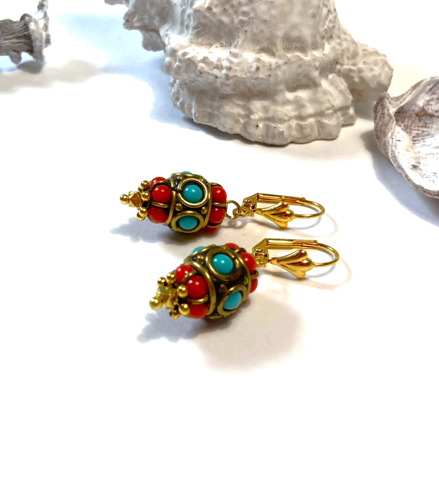 Turquoise met rode oorbellen in etnische stijl